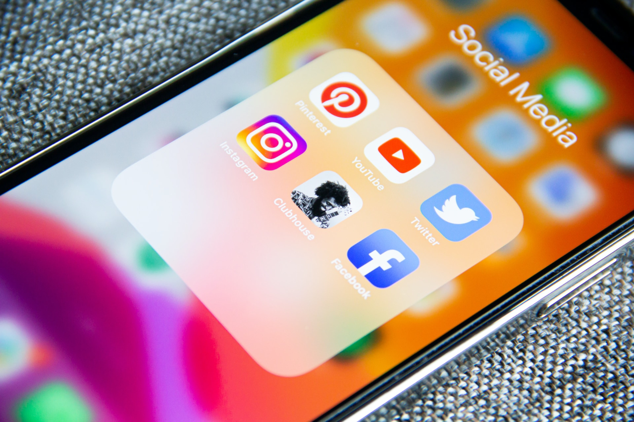A collage of icons representing different platforms like a website, social media logos, TikTok video frame, YouTube play button, and Pinterest pins on the screen of a smartphone.